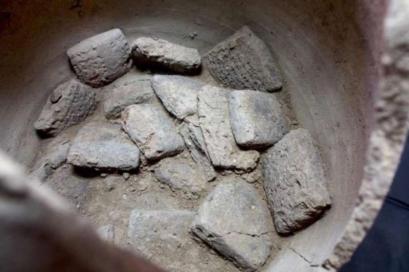 Las tablillas cuneiformes asirias en un recipiente de cerámica